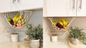 Netting hanging below a cabinet with fruit in it.