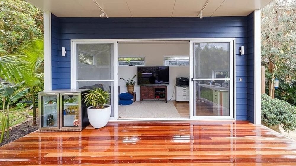 Sliding doors open to a living room and a polished deck.