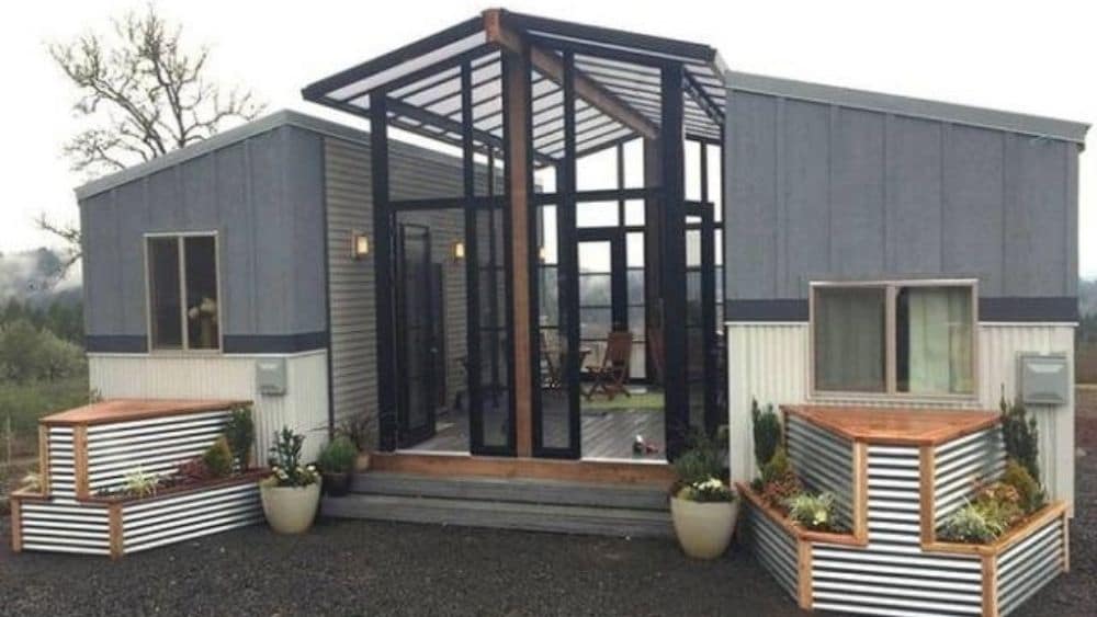 Two rectangular tiny homes with a covered sunroom connecting the two.