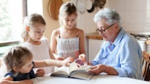 kids and an older person reading a book together.