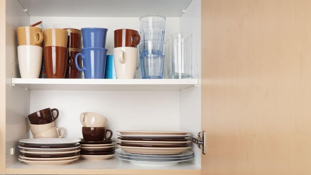 Kitchen cabinet with lots of cups and plates.