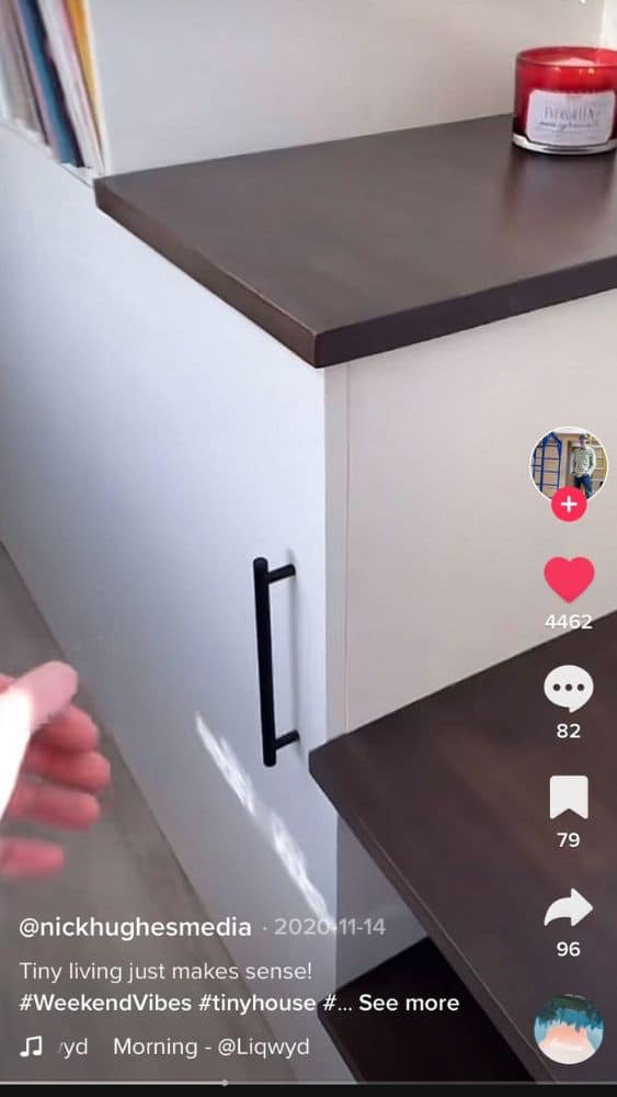 Screenshot of @nickhughesmedia's TikTok video that shows a hand reaching for a cabinet door under stairs.