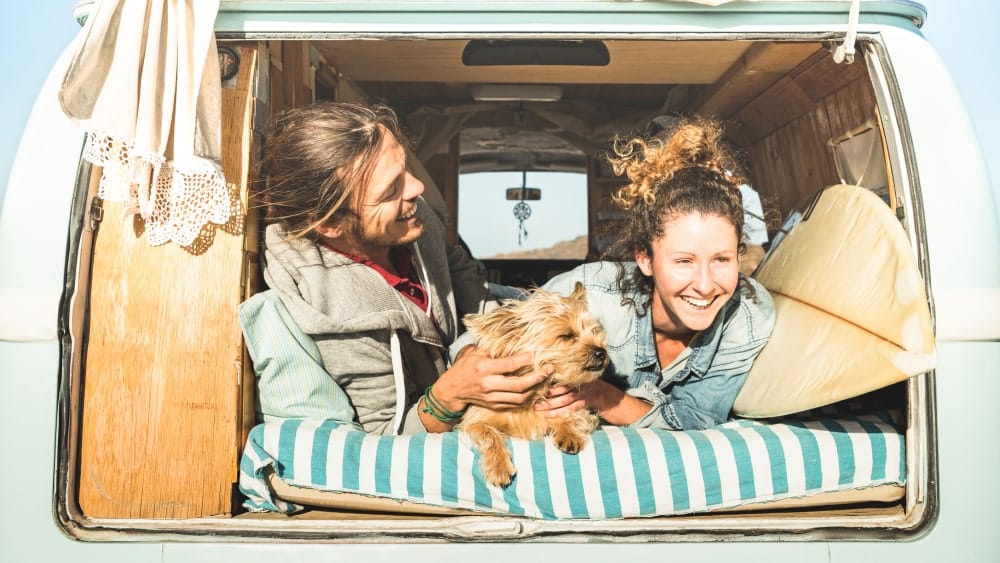 Young couple with their dog living in converted van